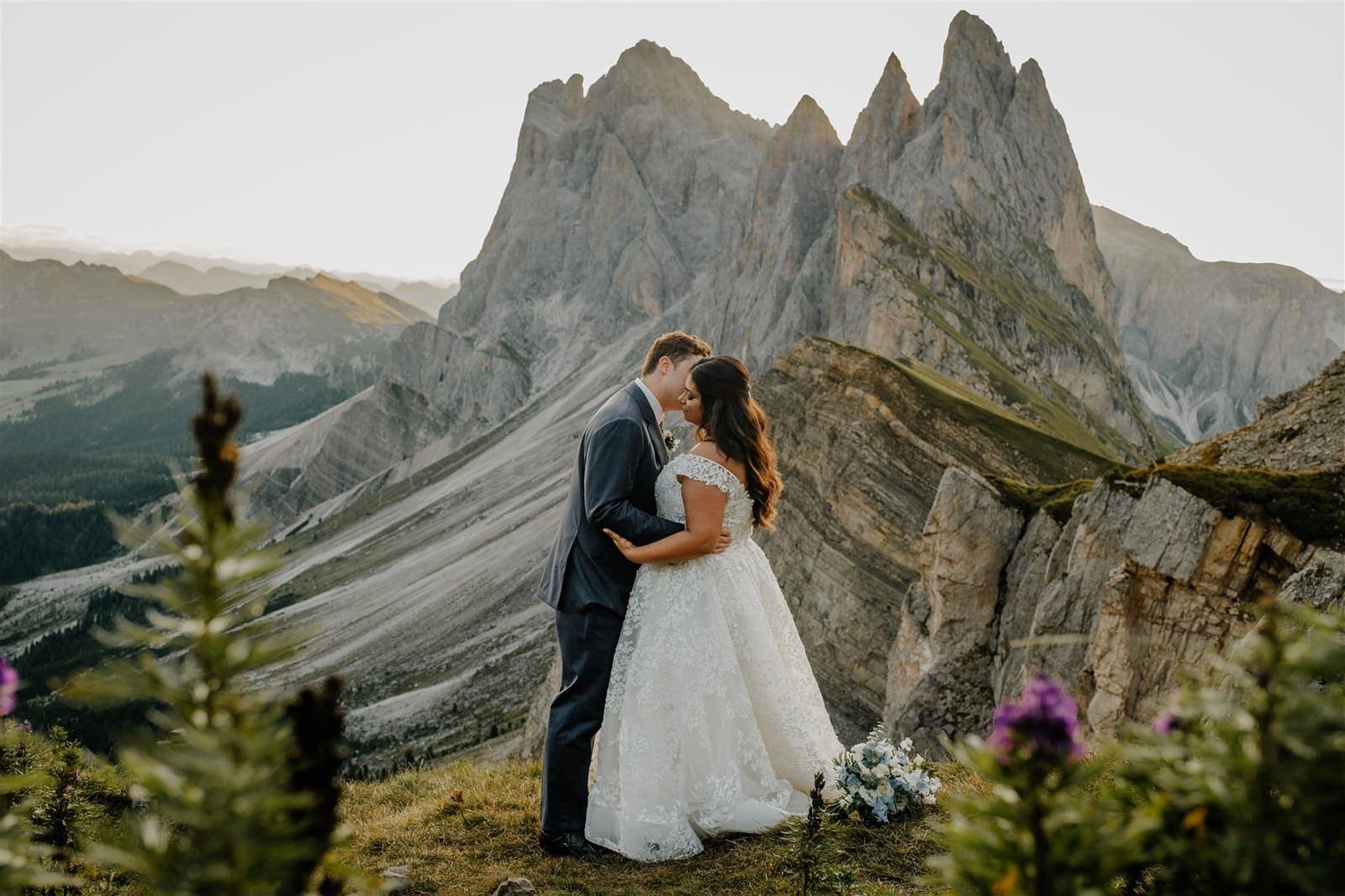 Couple kissing on a ridge in front of the jagged Odle peaks at Seceda, Val Gardena