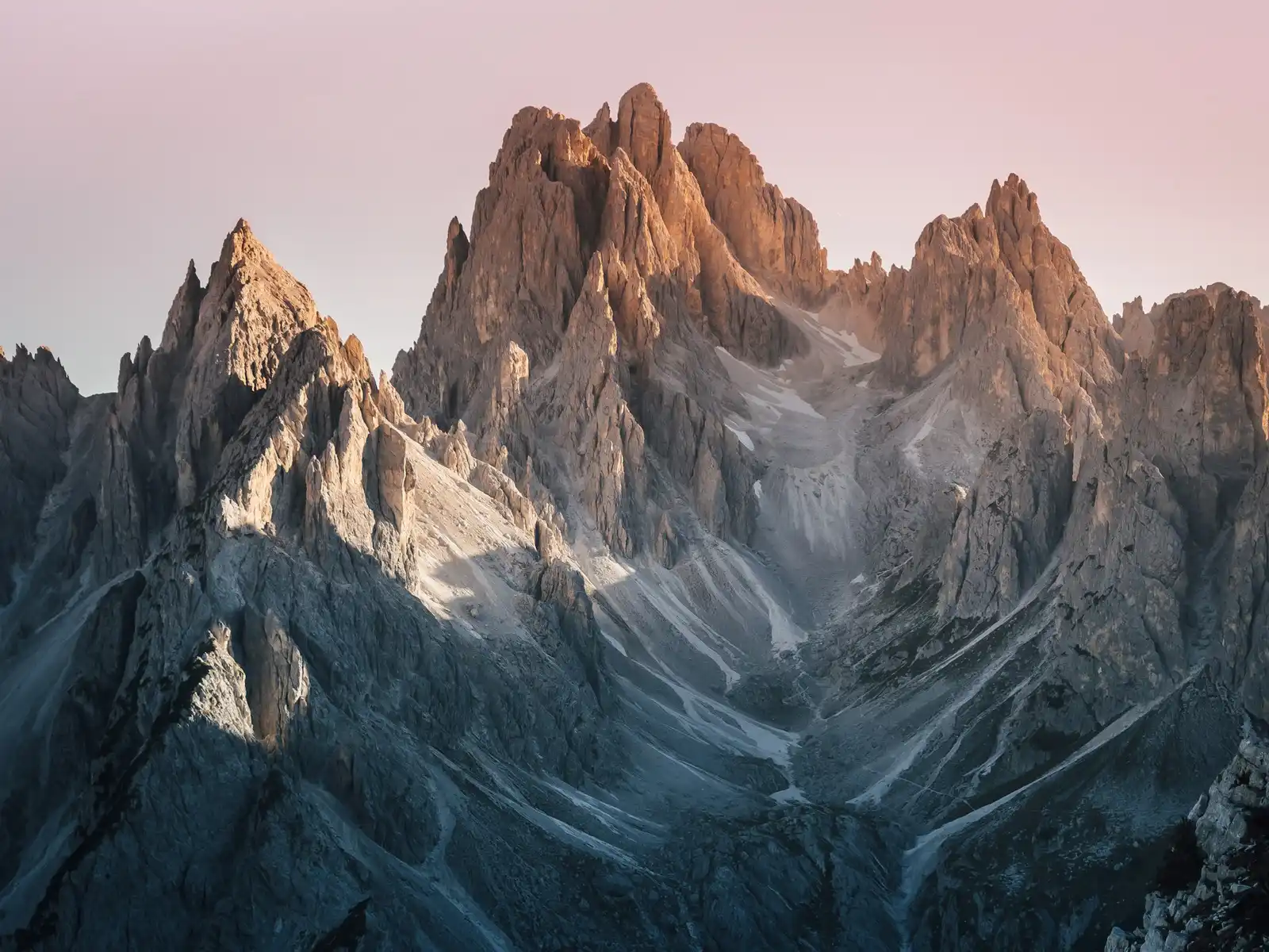 Cinque Torri Wedding & Elopement Photographer: Pricing & Packages Jagged Dolomites rock spires lit warm against a pink dusk sky