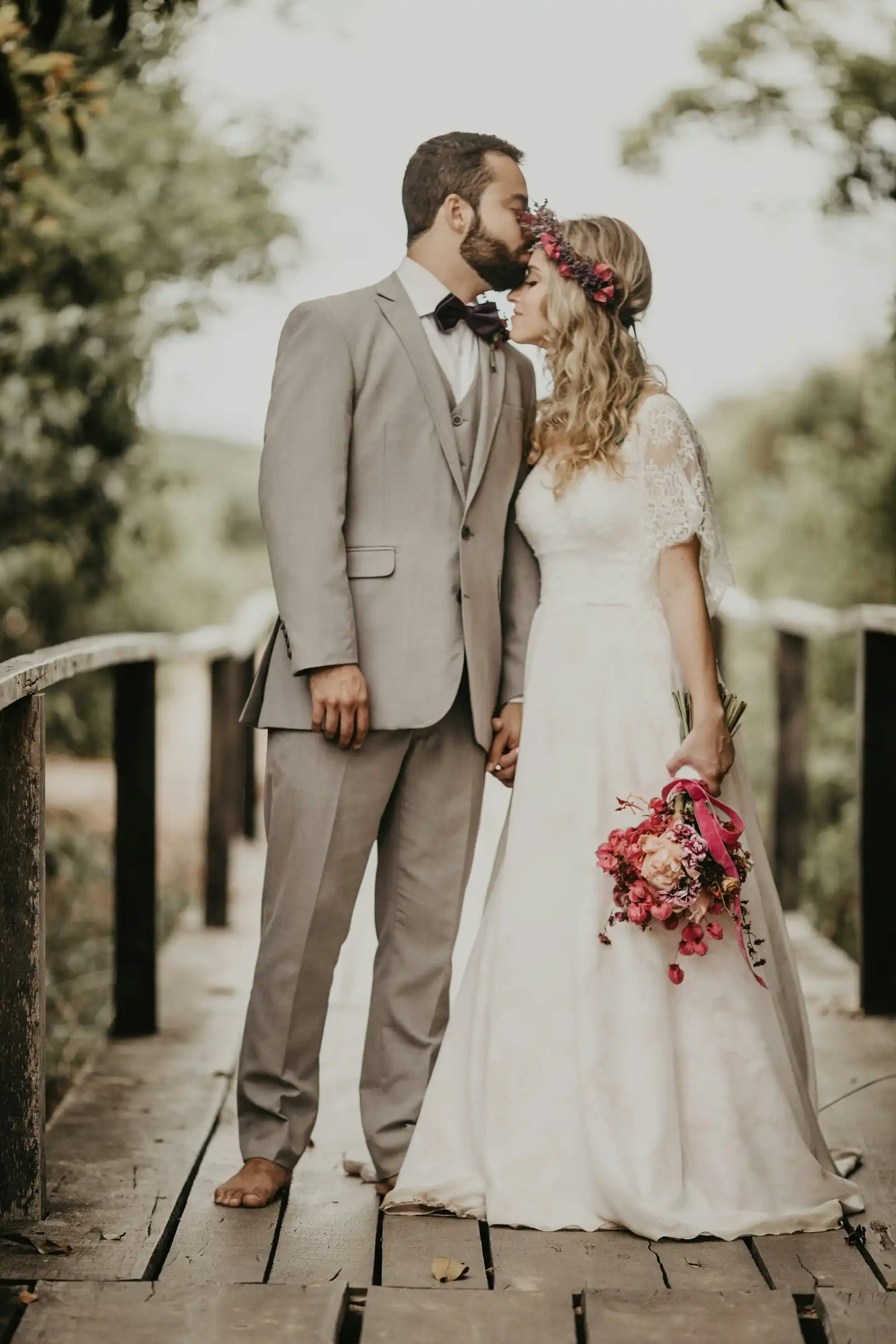 Full-Day Luxury Destination Wedding Elegant couple embracing on a wooden bridge during a luxury Dolomites wedding