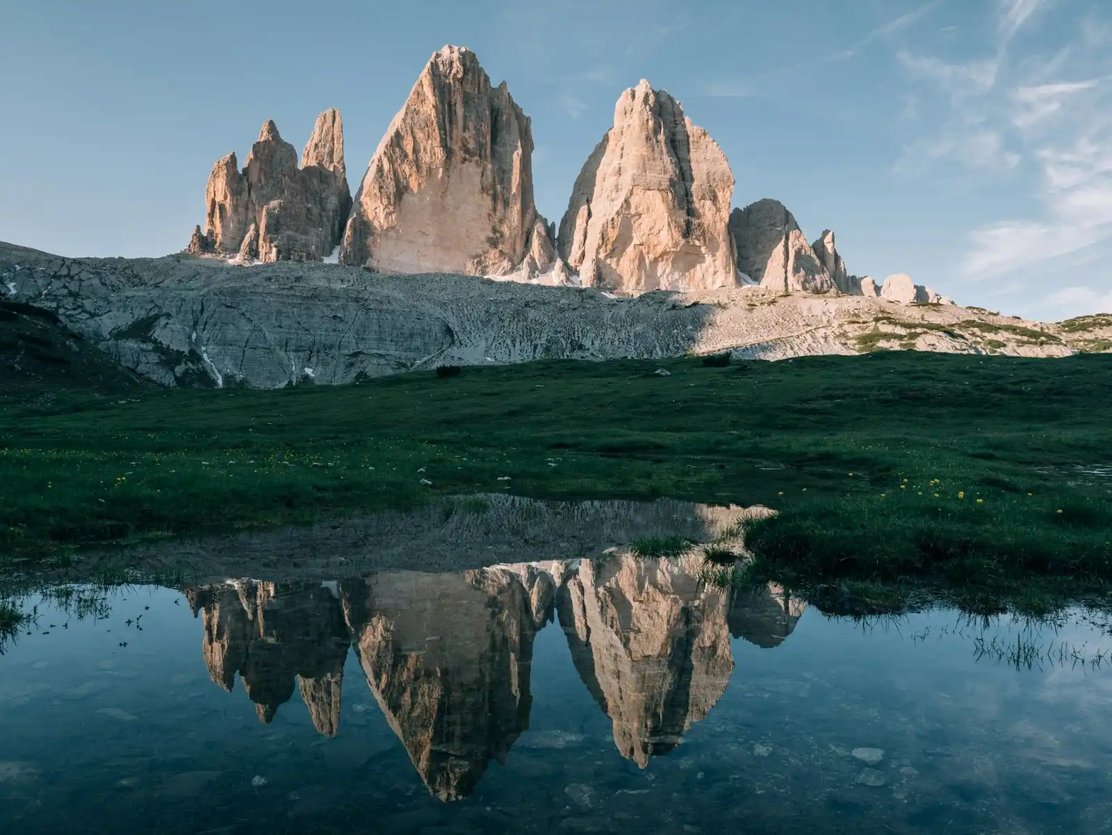 Helicopter Transfers and Luxury Add-Ons for a Dolomites Wedding Tre Cime di Lavaredo reflected in a small alpine pond