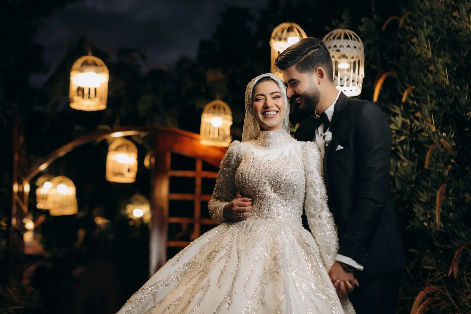 10 Most Beautiful Wedding Venues in the Dolomites for a Luxury Celebration Bride and groom smiling together in the warm glow of hanging lanterns at an evening celebration