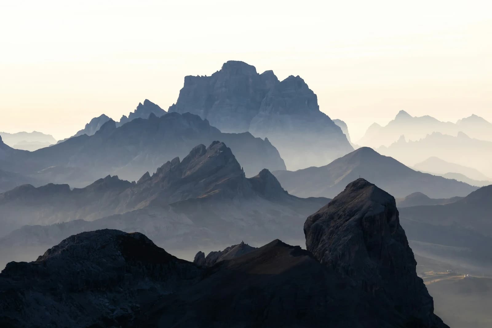 Marmolada Wedding & Elopement Photographer: Pricing & Packages Layered mountain ridges fading into mist beneath a pale sky